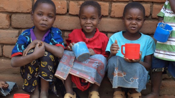 Malawi - feeding 3 girls - 3 girls with cups of food